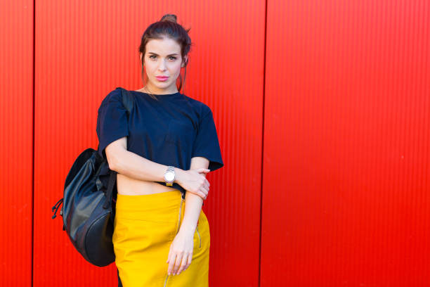 Pretty stylish woman in the city Pretty stylish woman standing against red wall color block stock pictures, royalty-free photos & images