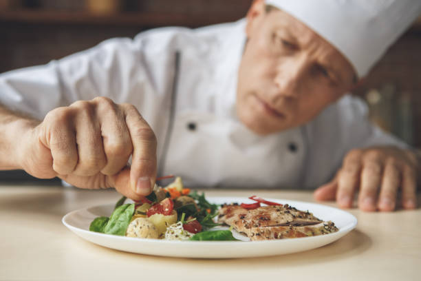 istock Mature man professional chef cooking meal indoors 827650670