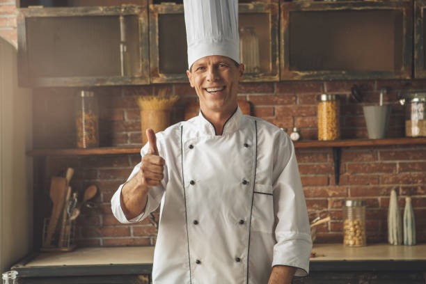 istock Mature man professional chef cooking meal indoors 827654560