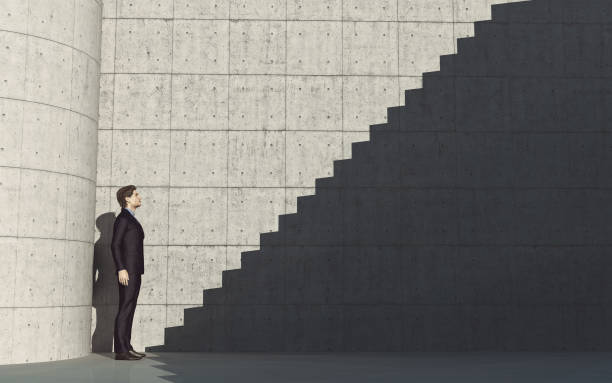istock Young man in front of stairs to success 827654592