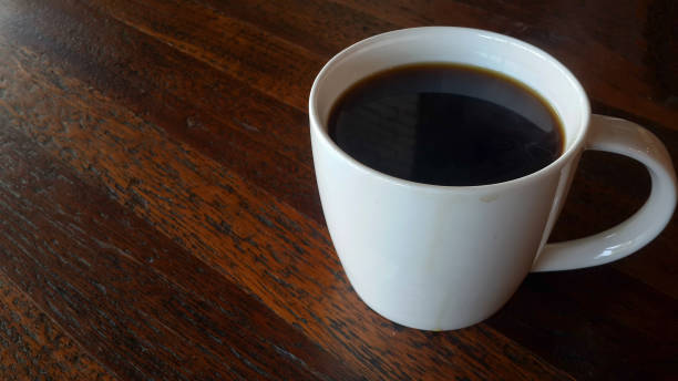 istock americano coffee in white mug on wooden table 827654630