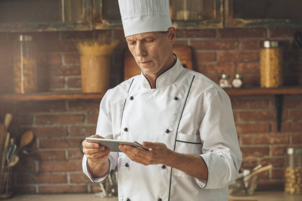 istock Mature man professional chef cooking meal indoors 827655276