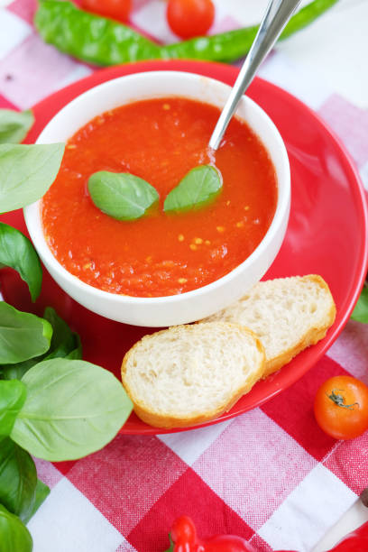 istock Cold summer tomato dish. Gaspacho soup with toast, cherry tomatoes, pepper, basil herbs. 827655504