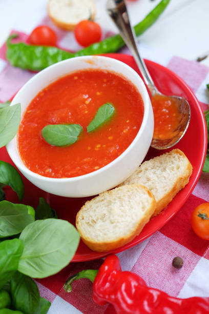 istock Cold summer tomato dish. Gaspacho soup with toast, cherry tomatoes, pepper, basil herbs. 827655508
