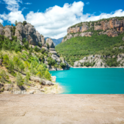 Stone border and defocused landscape - turquoise lake in mountains. Focus on foreground.