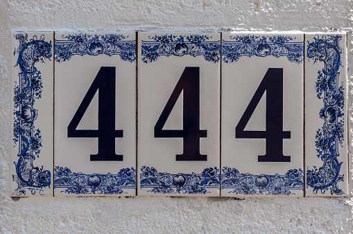 Number 444. Street number. Address. Plate on a wall