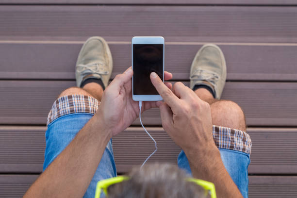 istock Young man sitting on stairs and using smartphone 827664058