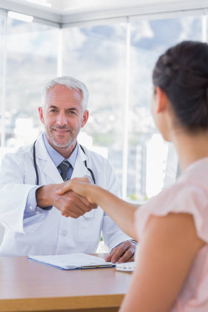 istock Cheerful doctor shaking hands to patient 827664348