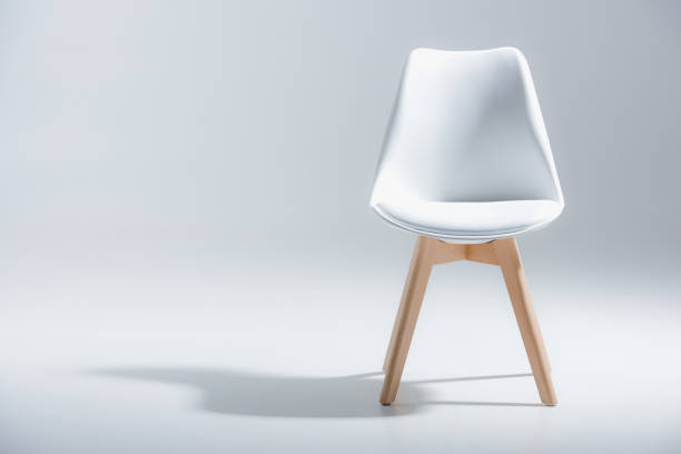 stylish chair with white top and light wooden legs standing on white Studio shot of stylish chair with white top and light wooden legs standing on white chair stock pictures, royalty-free photos & images