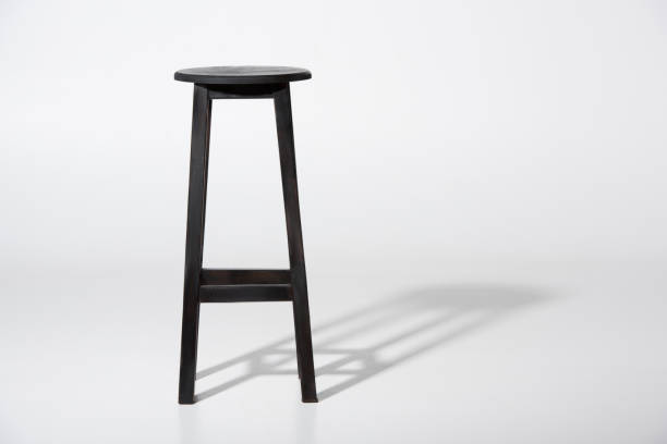 Studio shot of classic black tall wooden barstool standing on white Studio shot of classic black tall wooden barstool standing on white bar stool photos stock pictures, royalty-free photos & images