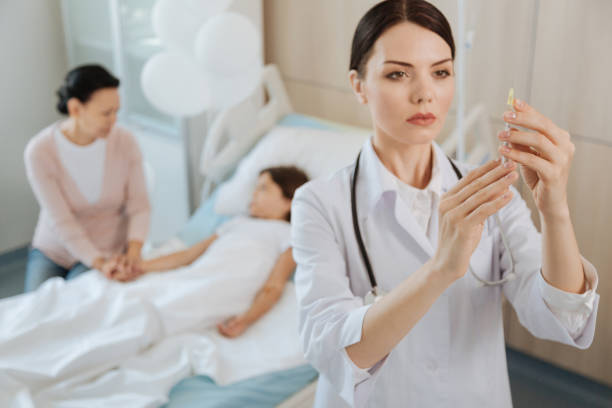 istock Serious skillful doctor preparing a syringe 827676742