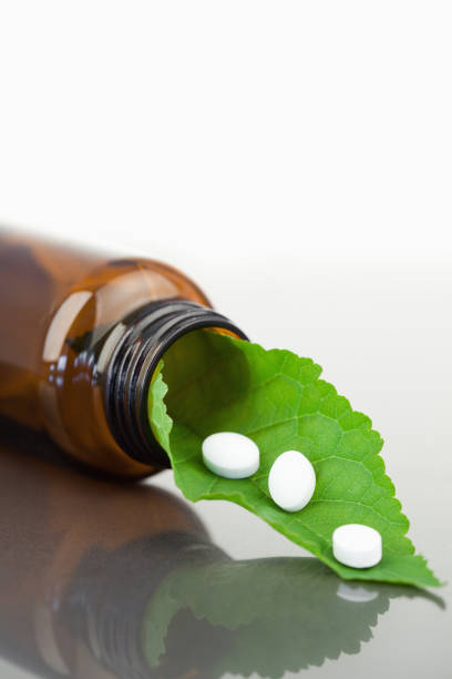 istock Leaf and pills in a small bottle 827679224