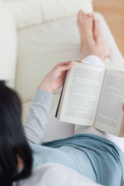 Woman reading a book with her legs crossed