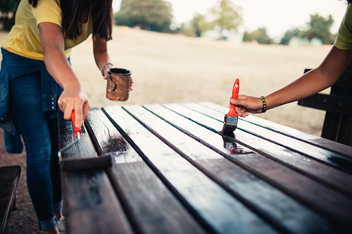 Photo of young woman and boy repairing  table in the park