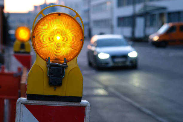 istock Warning lamp at a road construction with car 827683760