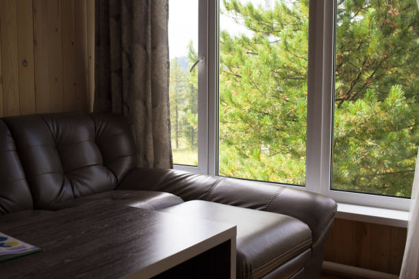 istock Table and sofa from the window with forest landscape. 827684234