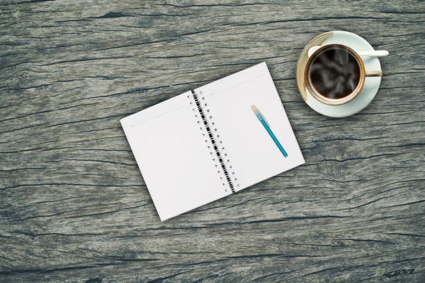 Hot black coffee and Open book on vintage wood background.