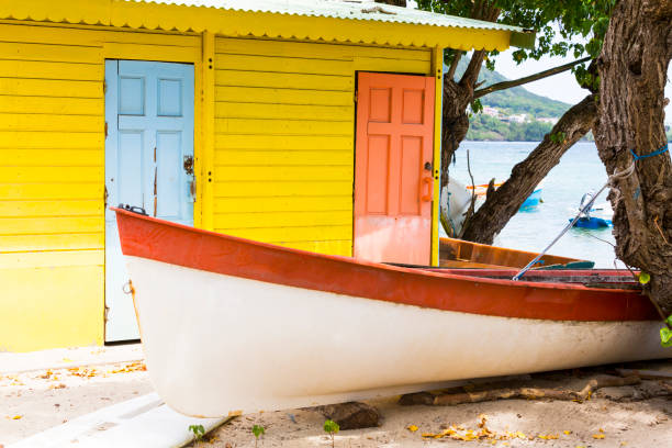 Colored wood house on beach yellow orange with small boat