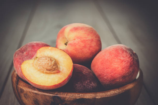 istock wooden bowl some fresh peaches on the table 827695244