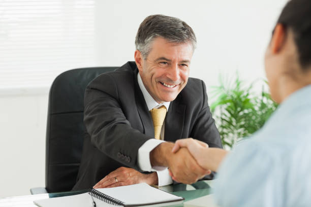 istock Man shaking a womans hand in an office 827696196
