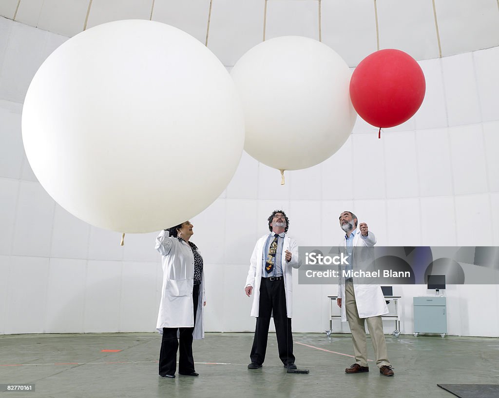 Científico de mirar hacia arriba en globos - Foto de stock de Globo del tiempo libre de derechos