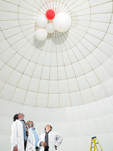 científico mirando hacia arriba en globos - globo del tiempo fotografías e imágenes de stock