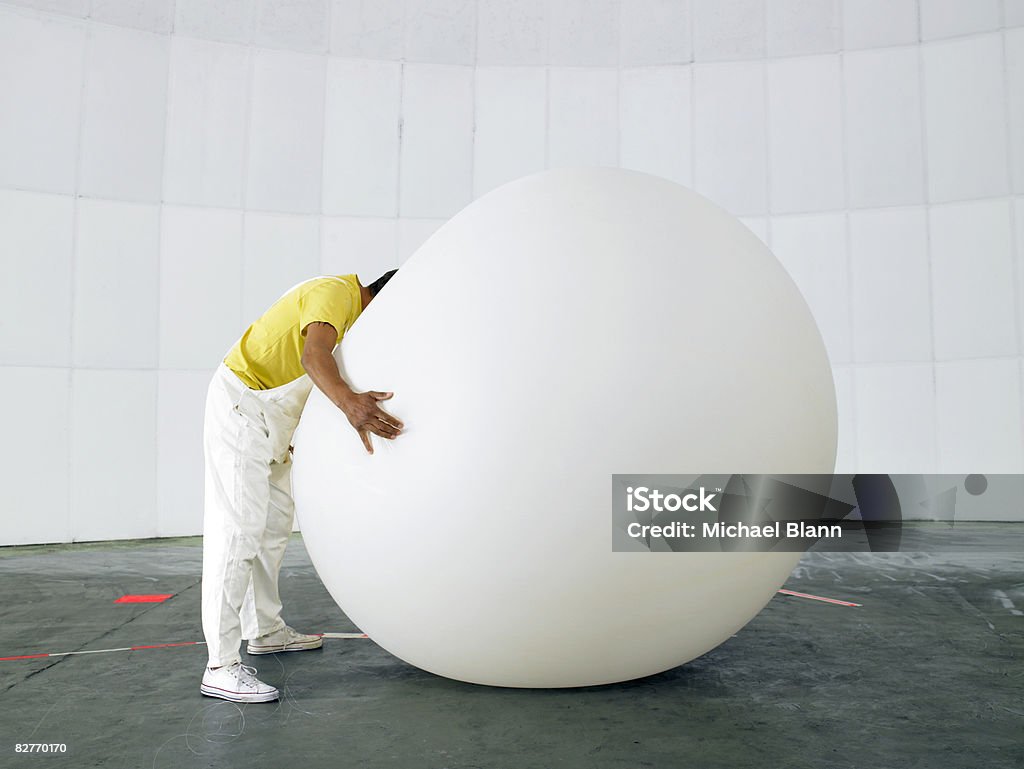 Man with head buried in huge weather balloon  Balloon Stock Photo