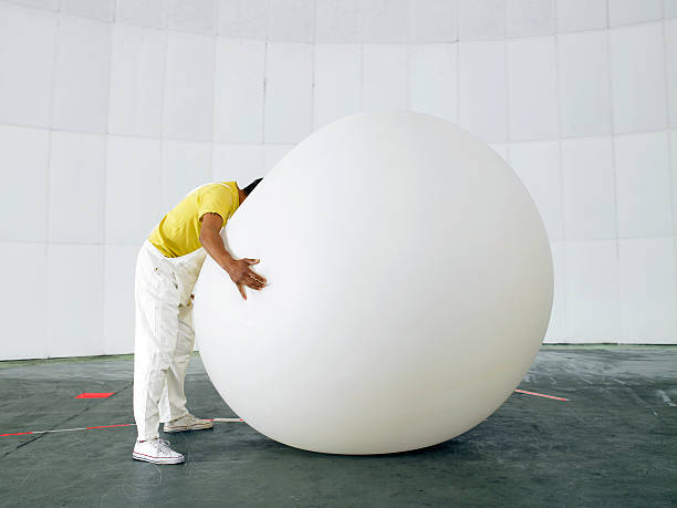 Man with head buried in huge weather balloon  weather balloon stock pictures, royalty-free photos & images