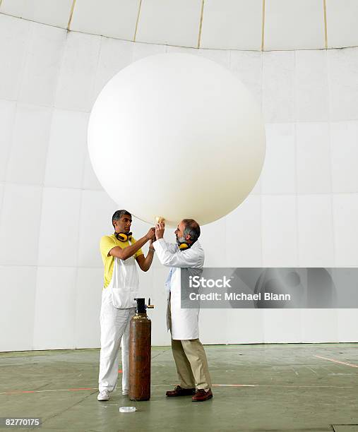 Scientists Inflate Weather Balloon In Lab Stock Photo - Download Image Now - Challenge, Fossil Fuel, Hand Raised