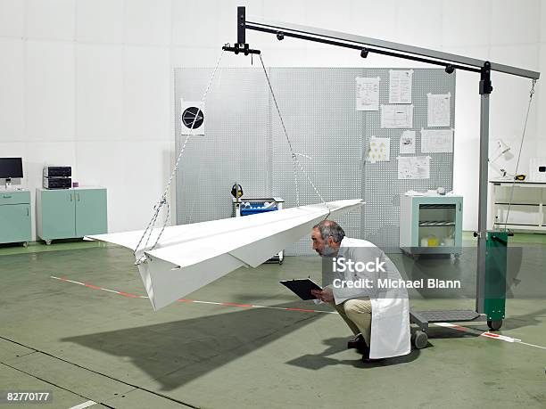 Scientist Inspecting Paper Plane In Laboratory Stock Photo - Download Image Now - Paper Airplane, Scientist, Development