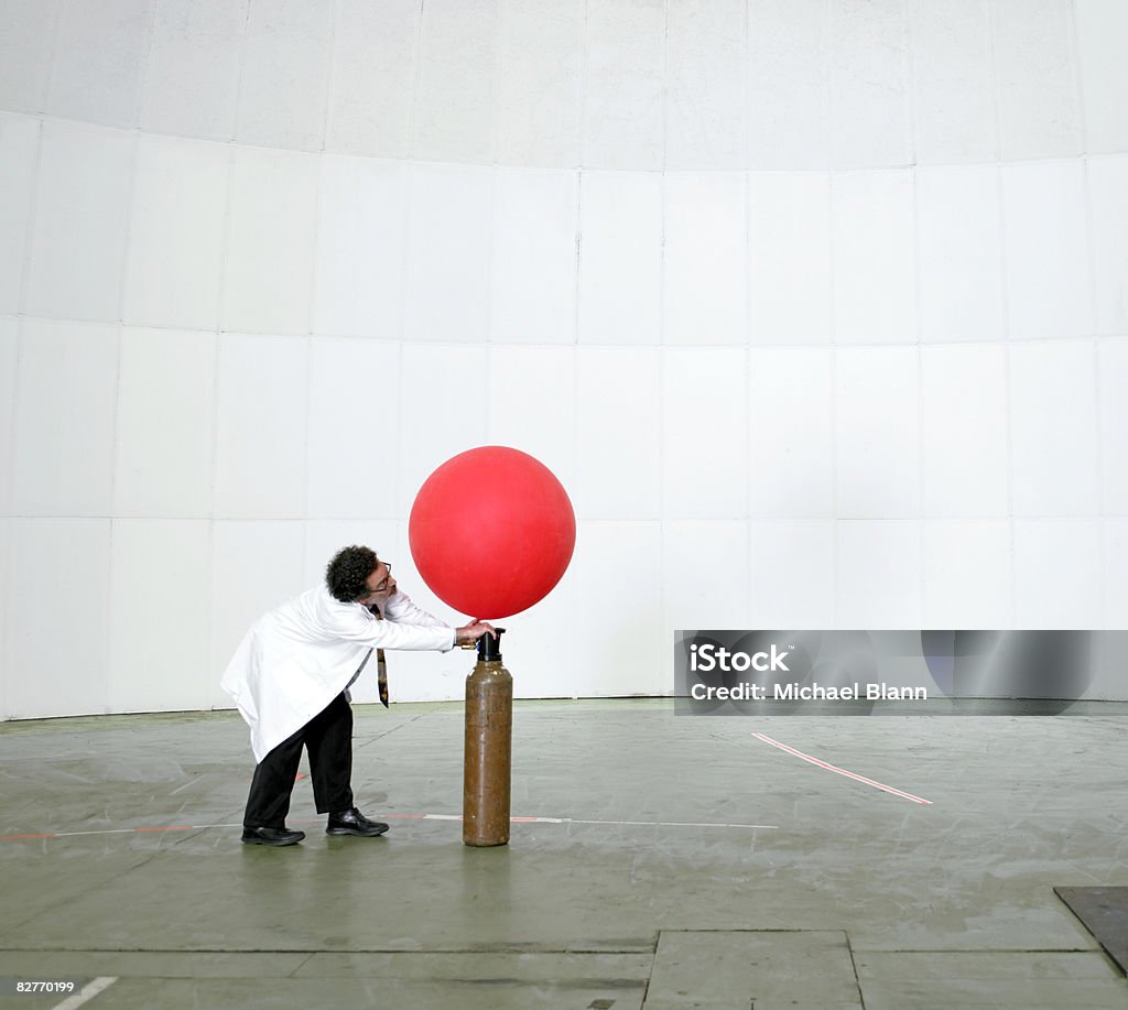 Scientist blowing up weather balloon with air  Balloon Stock Photo