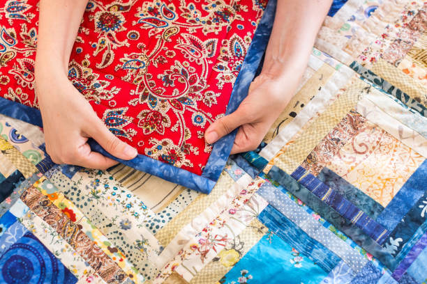 tradition, crafts, needlework. caucasian woman holds rag by hands in order to demonstrate the quality of needlework and beaty of ornament consist of traditional slav patterns - christmas quilt craft patchwork imagens e fotografias de stock