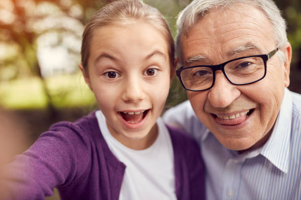 istock Disabled man and his granddaughter taking selfie 827708902