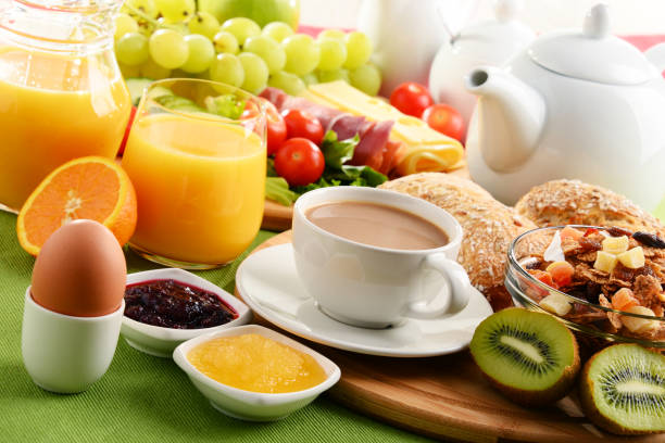 istock Breakfast served with coffee, orange juice, egg and fruits 827711720