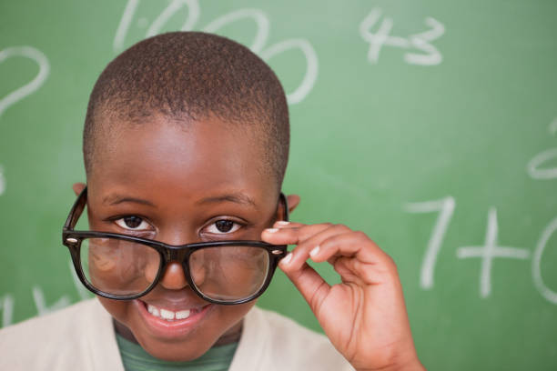 istock Smiling schoolboy looking over his glasses 827714508