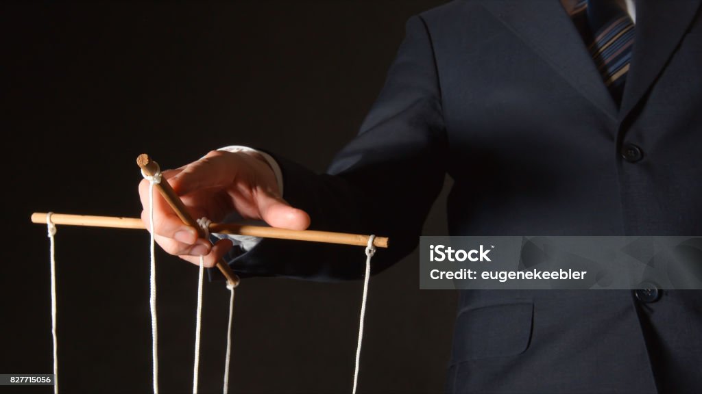 MANIPULATION: Businessman manipulating Puppet Stock Photo