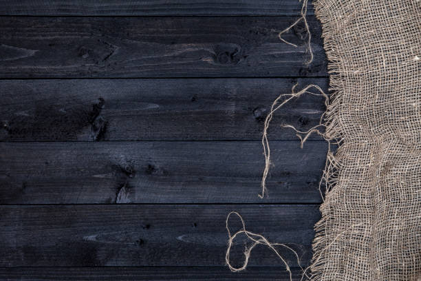 istock Black wooden table with burlap tablecloth, top view, copy space 827715104