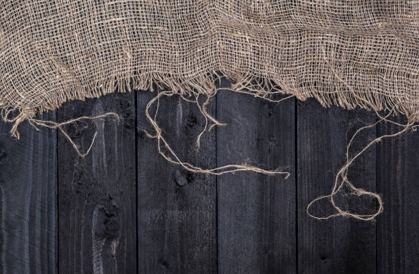 istock Black wooden table with burlap tablecloth, top view, copy space 827715154