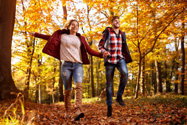 istock happy couple running through park 827715588