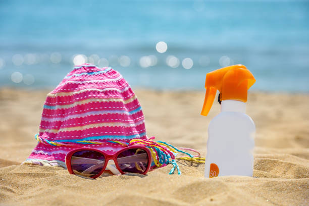 istock Bottle of sunscreen lotion on the sandy beach. 827718090