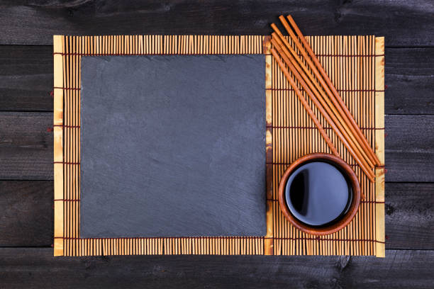 istock Bamboo mat and soy sauce on dark wooden table. Top view 827721504