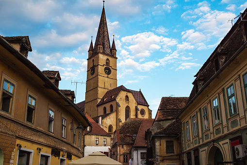 View on the Lutheran Cathedral tower in the street with medieval houses in Sibiu city, Romania.