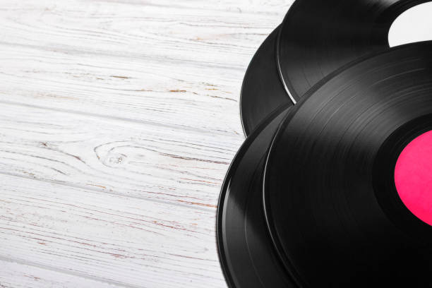 istock Top view of vinyl records stack over light wooden table with copy space for text 827729714