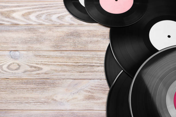 istock Retro vinyl records on the bright wooden background, selective focus. Top view. Copy space 827729752