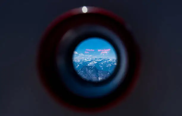 Alps mountain range looking from viewfinder of tourist binoculars on Zugspitze mountains