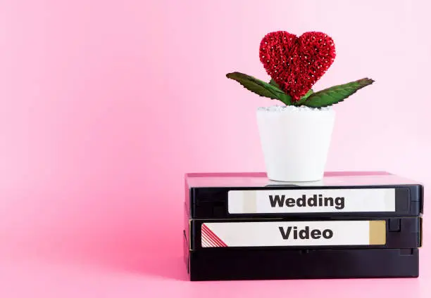 Photo of Video Tape for Wedding Video with love flower and pink copy space