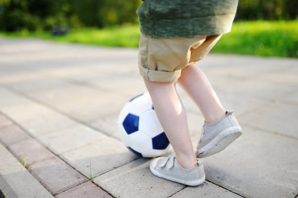 istock Little boy having fun playing a soccer game on sunny summer day 827739656