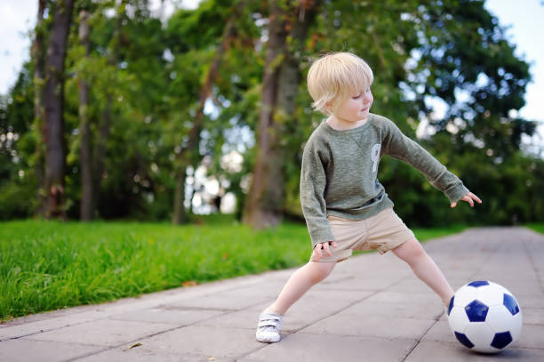 istock Little boy having fun playing a soccer game on sunny summer day 827739706