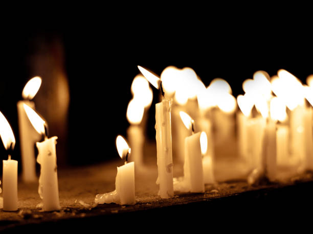 Group of lighting candles in black background, showing hope, faith, prayer, condolence, spirituality concept Group of lighting candles in black background, showing hope, faith, prayer, condolence, spirituality concept funeral parlor photos stock pictures, royalty-free photos & images