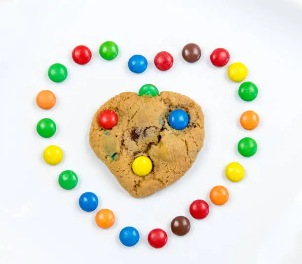 Delicious homemade sweet cookie inside a heart with colorful chocolate sweets